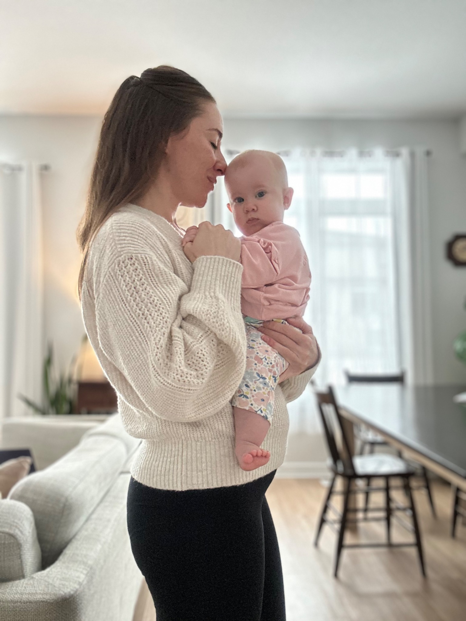 Christina holding her baby at home