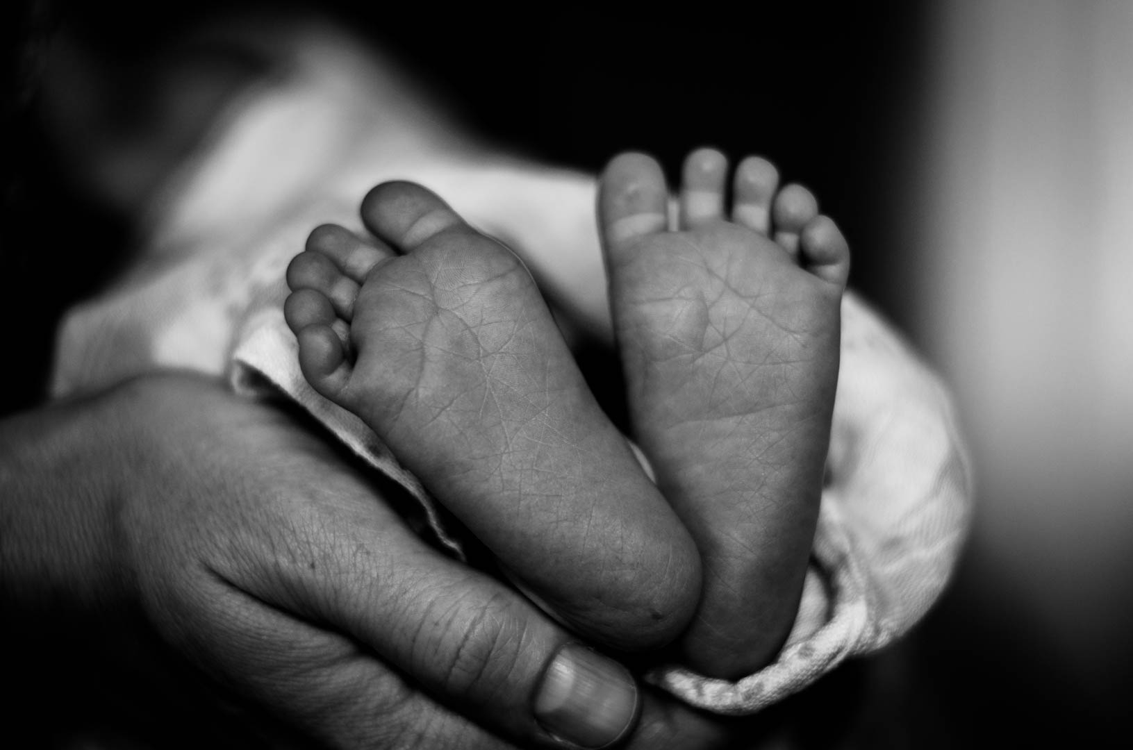 A mother holding her baby's hand